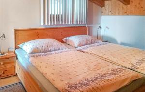 a bed with a wooden headboard and two pillows at Beautiful Apartment In Patsch With Wifi And 2 Bedrooms in Innsbruck