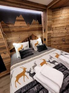 ein Schlafzimmer mit einem Bett in einer Blockhütte in der Unterkunft LES ARCS Appartement Prestige Ski In Ski Out in Bourg-Saint-Maurice