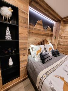 ein Schlafzimmer mit einem Bett in einer Holzwand in der Unterkunft LES ARCS Appartement Prestige Ski In Ski Out in Bourg-Saint-Maurice + 34 Fotos