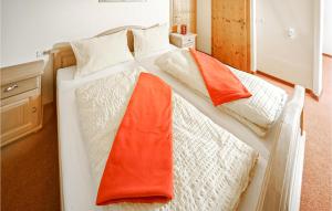 a bedroom with two beds with orange and white blankets at Haus Holzworm in Aussersiggam