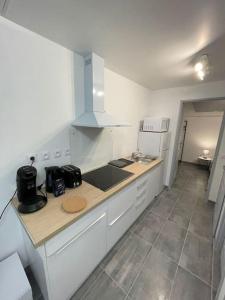 a kitchen with white cabinets and a counter top at La maisonnette Saint-quentinoise in Saint-Quentin