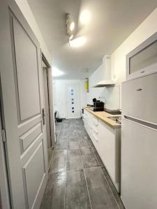 聖康坦的住宿－La maisonnette Saint-quentinoise，厨房配有白色冰箱,铺有瓷砖地板。