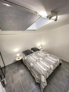 a bedroom with a bed in a white room at La maisonnette Saint-quentinoise in Saint-Quentin