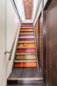 una escalera con escalones coloridos en un edificio en KIX House Wakeikan 和憩館, en Izumisano