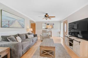 a living room with a couch and a tv at Palm Tree Paradise in Bradenton +42 photos