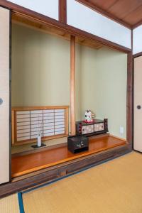 Habitación con ventana y mesa con radio. en KIX House Wakeikan 和憩館, en Izumisano