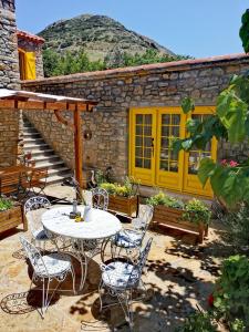 a patio with a table and chairs in front of a building at Ilios Guest House in Gokceada Town