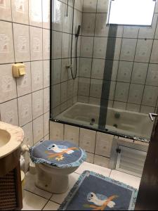 a bathroom with a shower and a toilet and a tub at Casa de Praia Navegantes - 100 metros do mar in Navegantes