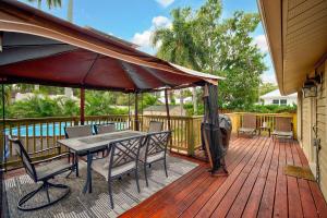 a deck with a table and chairs and an umbrella at Palm Tree Paradise in Bradenton