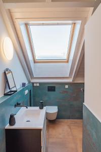 a skylight in a bathroom with a sink and a toilet at Schöne Wohnung mit Bergblick in Weilheim in Oberbayern