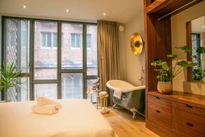 una camera con letto, vasca e finestra di Hammock Heights! Hot Tub,Private Garage,CityCentre a Manchester