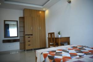 - une chambre avec un lit, une commode et un bureau dans l'établissement Aquavista lake view apartment, à Trivandrum