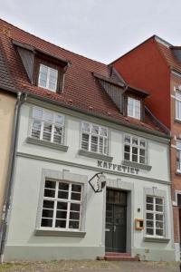 a white building with a harrier sign on it at Bändsel Herberge Kaffetiet - ABC363 in Wismar