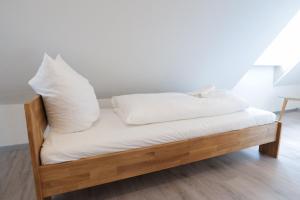 a bed with white pillows on top of it at Bändsel Herberge Kaffetiet - ABC363 in Wismar