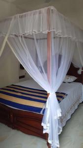 a bed with a canopy in a room at Blue sky villa in Mirissa