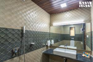 a bathroom with a sink and a mirror at Nautical Nook The Beach Villa- Pet Friendly by StayVista in Malvan