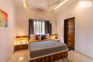a bedroom with a bed and a window at Nautical Nook The Beach Villa- Pet Friendly by StayVista in Malvan