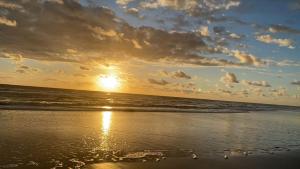 - un coucher de soleil sur une plage donnant sur l'océan dans l'établissement Chalé Sargi Serra Grande, à Serra Grande
