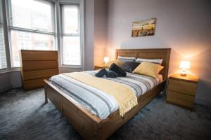una camera da letto con un grande letto in legno con due lampade di Blackpool Townhouse a Blackpool