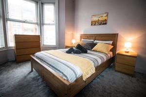 a bedroom with a large wooden bed with two lamps at Blackpool Townhouse in Blackpool