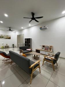 a living room with a ceiling fan and furniture at HeyFam Homestay in Sekinchan