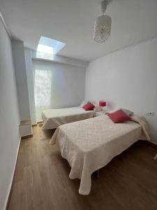 a white room with two beds and a window at Apto. Rural Cielo. Al lado Torre in Jérica