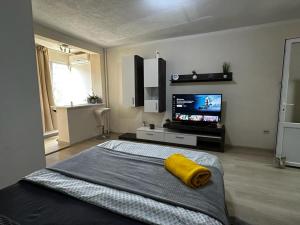 a bedroom with a large bed with a yellow pillow on it at REEAS APARTAMENT in Timişoara