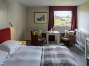 um quarto de hotel com uma cama, uma mesa e cadeiras em Westmorland Hotel Tebay em Tebay