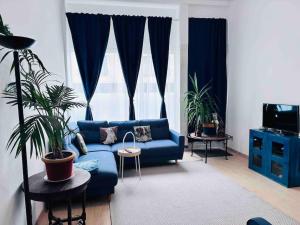 ein Wohnzimmer mit einem blauen Sofa und Pflanzen in der Unterkunft Cosy appartement près du centre in Brüssel
