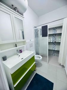 baño con lavabo verde y blanco y aseo en Cosy appartement près du centre, en Bruselas
