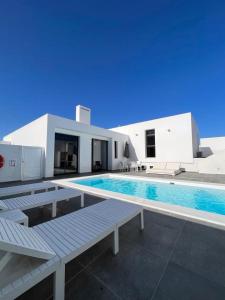 a swimming pool in front of a white house at Casa Blanca Teguise in Teguise