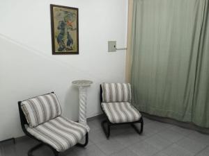 ルハン・デ・クージョにあるB&B Luján de Cuyoの椅子2脚とテーブル1台と写真1枚が備わる部屋