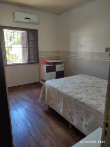 een lege kamer met een bed en een raam bij Casa de campo, Piscina e Cristo in Encantado