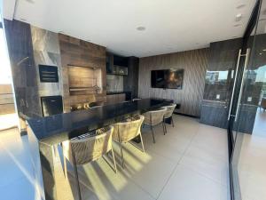 a kitchen with a bar with chairs and a counter top at Apartamento 1Dorm piso 14 Equipe in Santa Cruz de la Sierra
