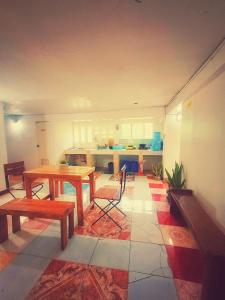 San Juanico Travellers Inn - RedDoorz في تاكلوبان: غرفة معيشة مع طاولة ومطبخ