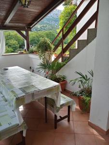 une table et un banc sur un balcon avec des plantes dans l'établissement Apartmani Seršić, à Baška