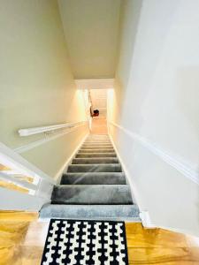 a stairway with a black and white checkered rug at Ravensbury Home in Mitcham