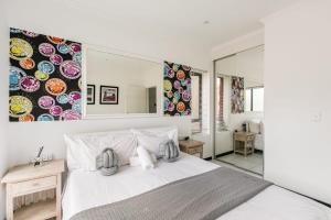a bedroom with a large white bed and a mirror at Nova Luxury Suites Fourways in Johannesburg