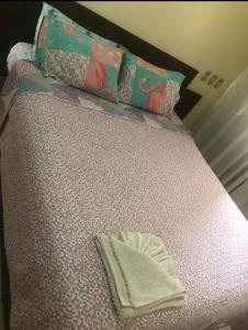 a bed with a pillow and a towel on it at Casa de Praia Navegantes - 100 metros do mar in Navegantes