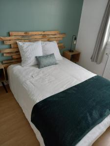 1 dormitorio con 1 cama grande y cabecero de madera en Chambre dans maison, en Baillet-en-France