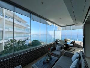 een woonkamer met grote ramen en uitzicht op de oceaan bij Sunset Lover Sea View Luxury Apartment in Tanger