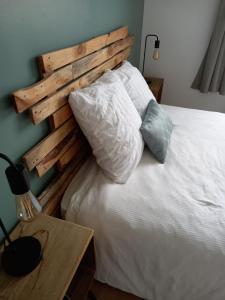 1 cama con cabecero de madera junto a una mesa en Chambre dans maison, en Baillet-en-France