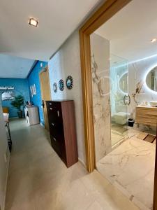 een badkamer met een glazen douche en een wastafel bij Sunset Lover Sea View Luxury Apartment in Tanger