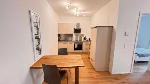 a kitchen and dining room with a wooden table and chairs at Trier City Center Apartments Altstadt in Trier