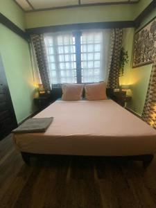 ein großes Bett in einem Zimmer mit Fenster in der Unterkunft La Villa Saint Jean in Cotonou