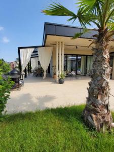 uma casa com uma palmeira em frente em Luxury Villas Giardino Lozenetz em Lozenets