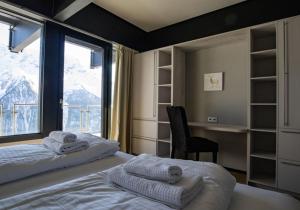 um quarto com uma cama, uma secretária e uma janela em Lauchernalp Resort Residences em Wiler