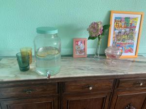 une table avec un pot en verre au-dessus d'une armoire dans l'établissement casa loopez Hostel, à Laredo