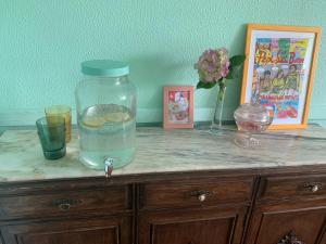 a table with a glass jar on top of a cabinet at casa loopez Hostel in Laredo