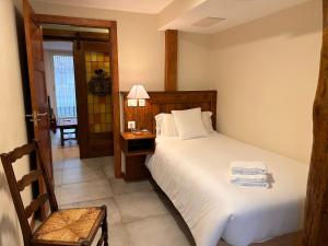 1 dormitorio con 1 cama y 1 mesa con lámpara en Magdalenea - Apartamento, en Lesaka